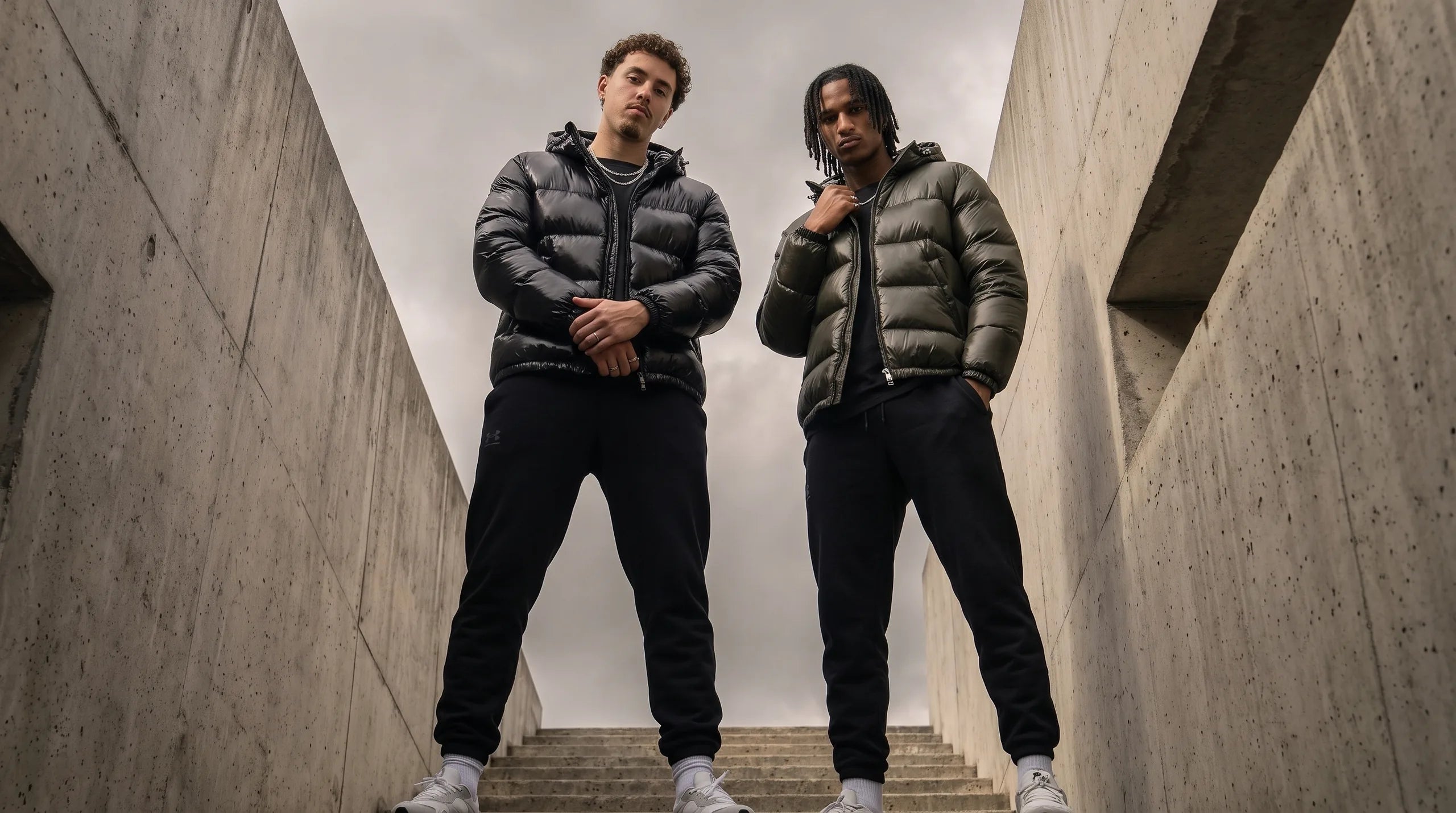 Deux hommes en doudoune à capuche WAITYX, coloris noir et kaki, escalier béton